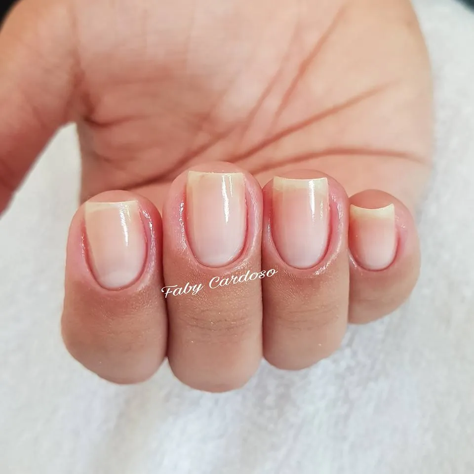 Unhas com cutilagem fina e esmaltação nude
